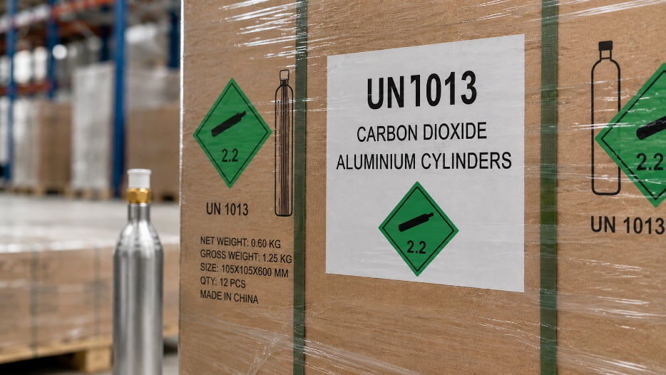 A pallet of CO2 cylinders properly packaged and labeled for international shipping.